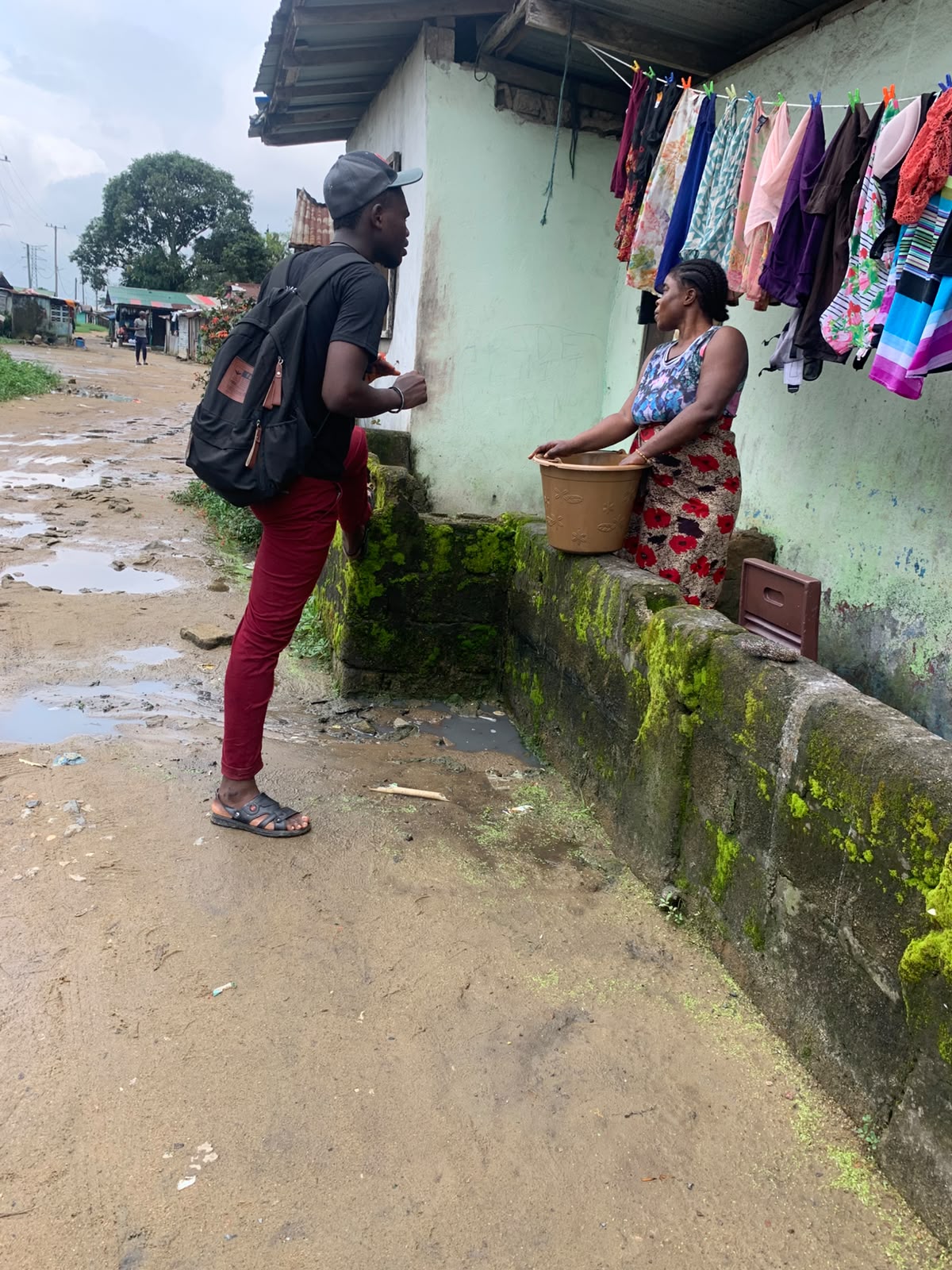 A Yinava team member speaking with a woman during an LPG adoption field visit